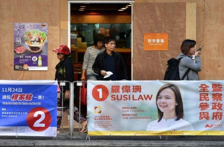 Des passants devant des affiches électorales dans le quartier de Wanchai à Hong Kong le 22 novembre 2019