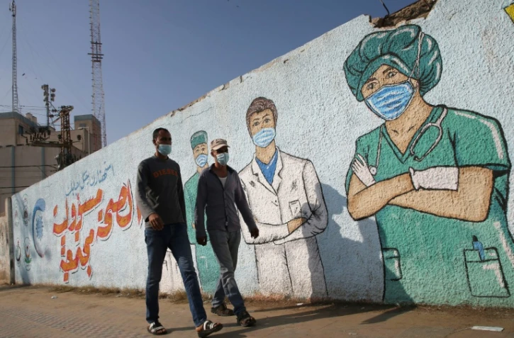 Des soignants masqués sur une fresque murale à Khan Younes dans la bande de Gaza le 12 novembre 2020 