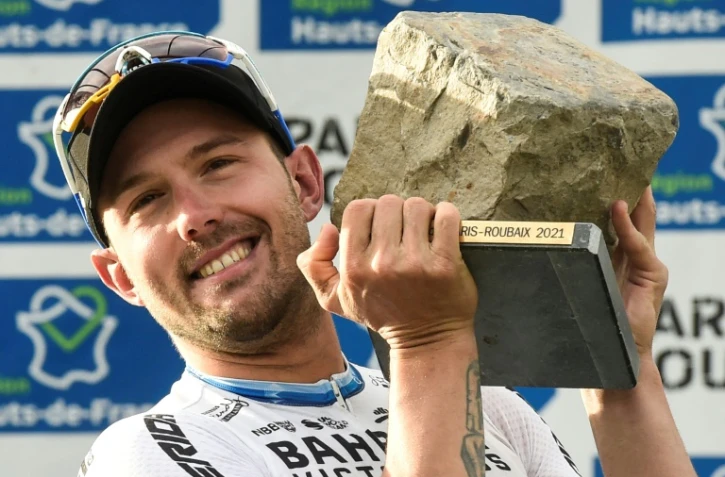 L'Italien Sonny Colbrelli soulève le trophée de Paris-Roubaix, en forme de pavé, après avoir remporté la course à sa 1ère participation, en battant au sprint le Belge Florian Vermeersch et le Belge Mathieu Van Der Poel, le 3 octobre 2021 sur le vélodrome de Roubaix
