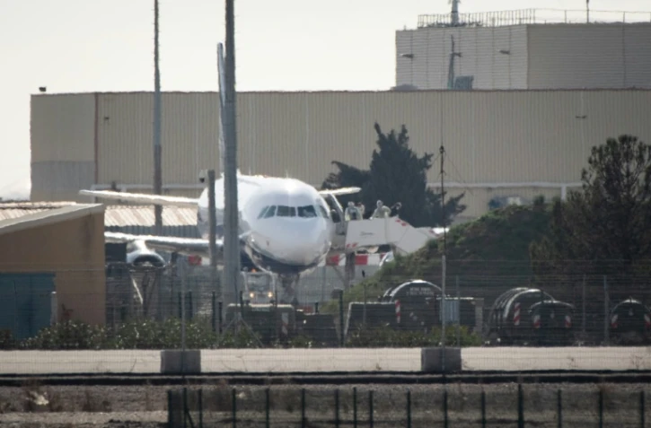 Des passagers portant des masques de protection débarquent d'un avion à Istres, le 9 février 2020  