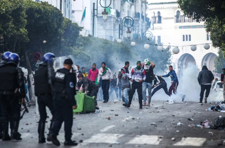 Des manifestants algériens affrontent des policiers anti-émeutes lors d'une nouvelle journée de contestation à Alger le 12 avril 2019