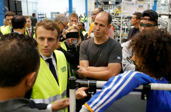 Emmanuel Macron, en gilet jaune, parle avec les employés de l'usine Whirlpool d'Amiens, le 3 octobre 2017