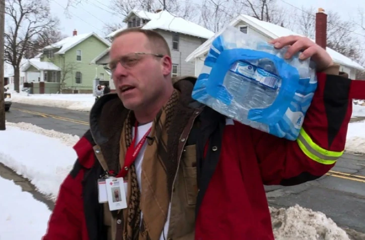 Un volontaire de la Croix rouge américaine livre des packs de bouteilles d'eau aux habitants de Flint