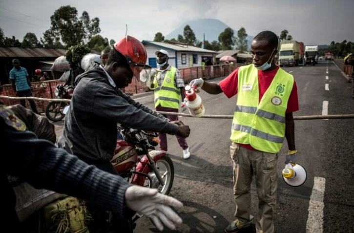 Un conduteur de moto-taxi se fait laver les mains sur la route entre Butembo et Goma, en RD Congo, dans le cadre de la lutte contre l'épidémie d'Ebola, le 16 juillet 2019