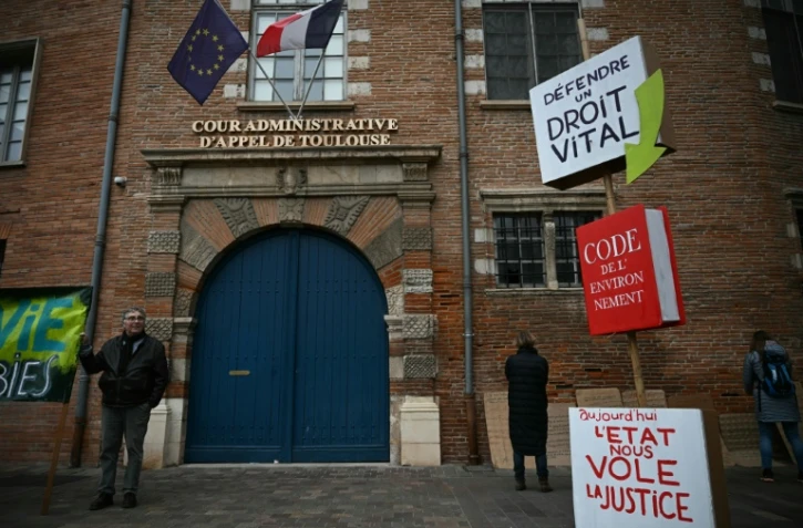 Un homme brandit une pancarte lors d’une manifestation contre le projet d’autoroute A69, devant la cour administrative d’appel à Toulouse, le 11 décembre 2025