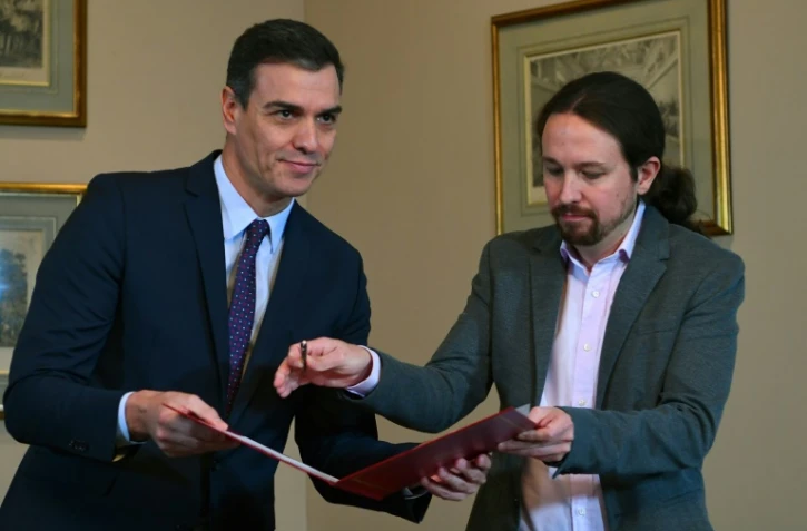 Le Premier ministre espagnol Pedro Sanchez et le leader de Podemos Pablo Iglesias signent un accord de pour former un gouvernement Ă Madrid le 12 novembre 2019