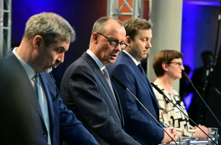 Le conservateur (CDU) allemand Friedrich Merz (au centre) dévoile son accord de gouvernement avec les sociaux-démocrates, le 9 avril 2025 à Berlin
