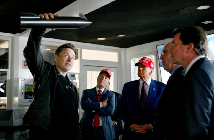 Elon Musk (g) et le président élu américain Donald Trump (3e g) dans une salle de contrôle avant le lancement d'un vol d'essai de la fusée Starship de SpaceX, le 19 novembre 2024 à Brownsville, au Texas