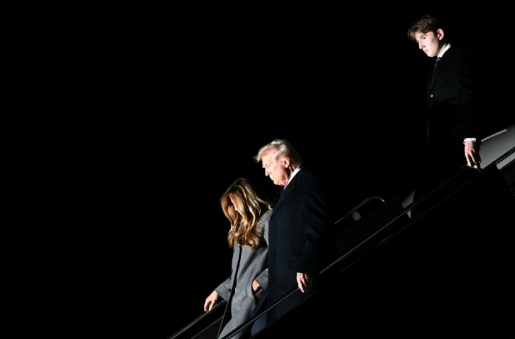 Le président élu Donald Trump, son épouse Melania et leur fils Barron débarquent le 18 janvier 2025 à l'aéroport Dulles en Virginie, en banlieue de la capitale des Etats-Unis, Washington.