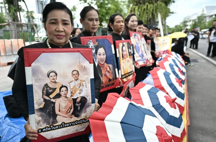Des personnes en deuil tiennent des portraits de la défunte princesse thaïlandaise Bajrakitiyabha Mahidol devant le Grand Palais de Bangkok, le 13 juin 2026