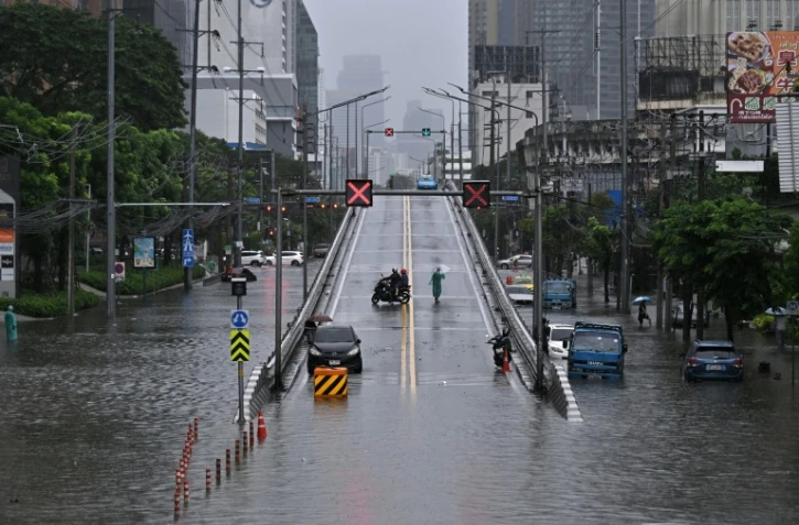 Des automobilistes font demi-tour depuis un pont surplombant des eaux de crue le long de la route Phetchaburi à Bangkok, le 26 septembre 2026