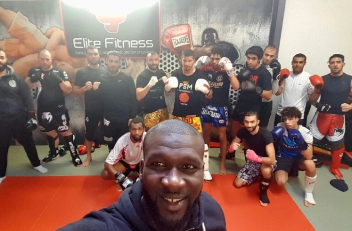 Photo prise le 10 mai 2016 à Créteil de l'ex-champion de France de boxe thaï Amadou Ba posant avec des membres de son club "Magic Créteil"