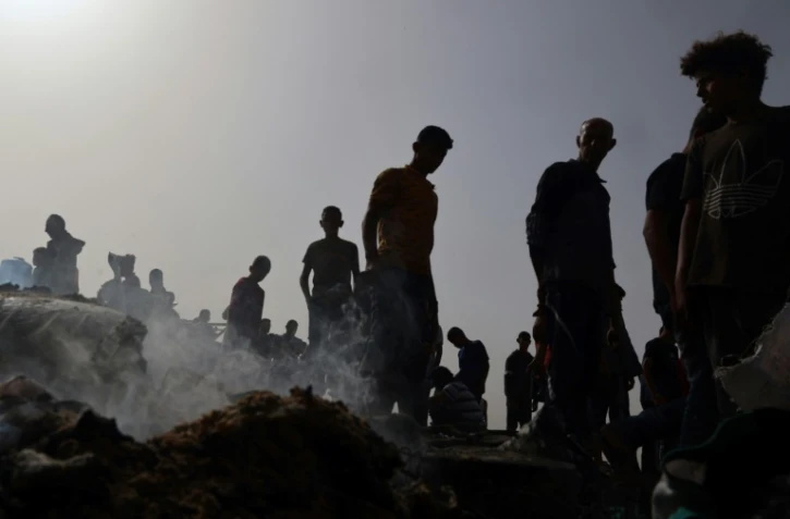 Des Palestiniens constatent les dégâts dans le camp pour personnes déplacées bombardé par l'armée israélienne à Rafah, dans le sud de la bande de Gaza, le 27 mai 2024