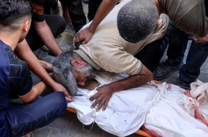 Un Palestinien pleure sur le corps d'un proche tué dans des bombardements israéliens à Nousseirat, dans le centre de la bande de Gaza, le 16 septembre 2024