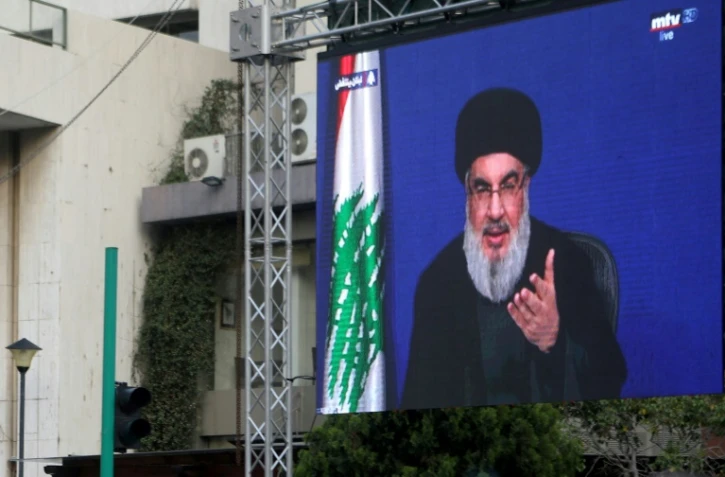 Photo prise le 25 octobre 2019 à Beyrouth montrant le chef du Hezbollah, Hassan Nasrallah, s'exprimant sur un écran géant au 9e jour d'une mobilisation inédite contre la classe politique qui paralyse le Liban.