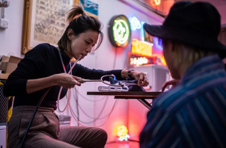 Karen Chan travaillant sur un tube de néon dans un atelier de Hong Kong, le 25 novembre 2021