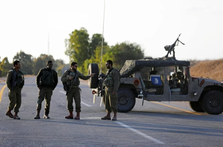 Des soldats israéliens bloquent une route à proximité de la frontière avec la bande de Gaza, le 30 octobre 2017, alors que le bombardement d'un tunnel par Israël a fait trois morts côté palestinien