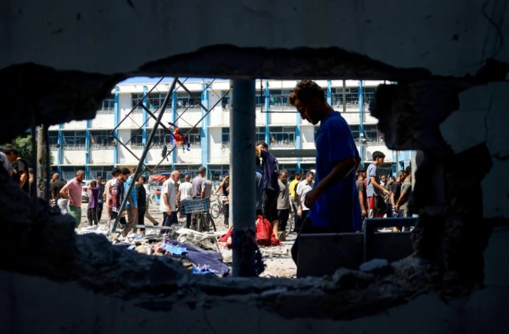 Des Palestiniens inspectent les dégâts à l'école Al-Razi gérée par l'ONU dans le camp de réfugiés de Nousseirat dans le centre de la bande de Gaza, après une frappe israélienne, le 16 juillet 2024