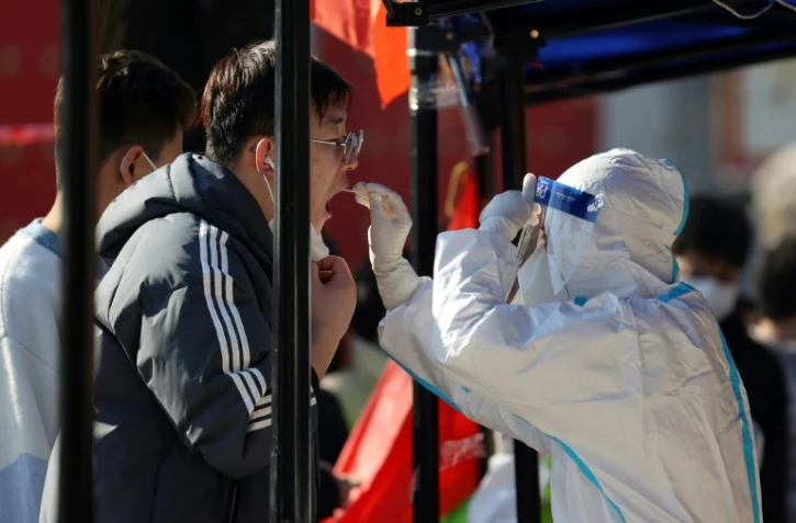 Un habitant se fait tester au Covid-19, le 21 décembre 2021 à Xi'an, dans le nord de la Chine