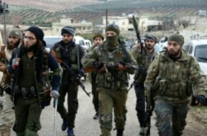 Des rebelles syriens alliés aux forces turques entrent dans un village au nord d'Afrine, dans le nord-ouest de la Syrie, le 16 mars 2018