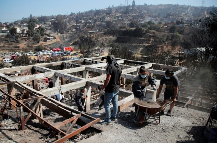 Des habitants enlèvent les débris des maisons à Villa Independencia, au Chili, le 5 février 2024