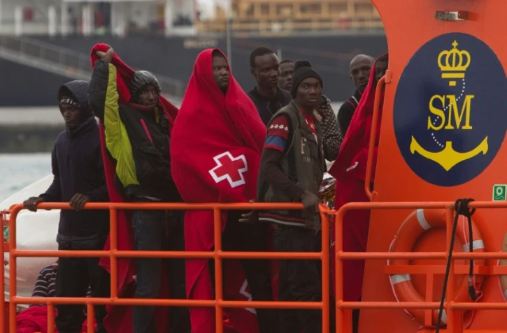 Un groupe de migrants arrive dans le port espagnol de Malaga à bord d'un bateau des garde-côtes qui les a secourus en mer le 3 décembre 2016