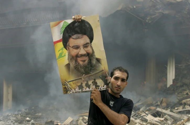 Un Libanais brandit une photo de Hassan Nasrallah après des frappes aériennes israéliennes sur un bastion du Hezbollah à Beyrouth, le 23 juillet 2006