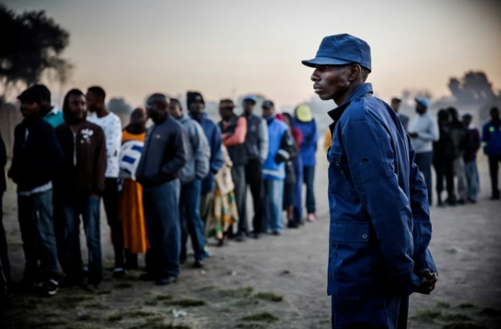 Un policier zimbabwéen contrôle les accès d'un bureau de vote dans la banlieue de Harare, le 30 juillet 2018