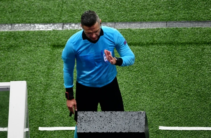 L'arbitre Damir Skomina consulte la VAR et accorde un penalty pour une main de Kimpembe lors de PSG-Manchester United, le 6 mars 2019 au Parc des Princes