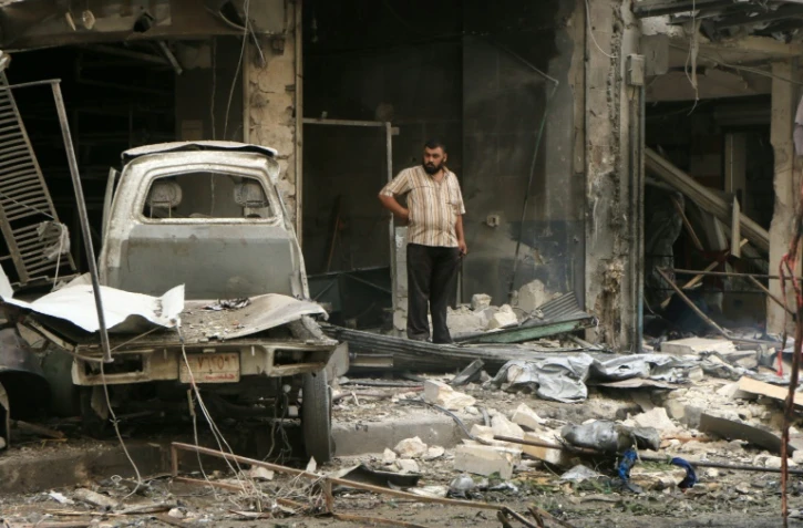 Un Syrien au milieu des ruines après des frappes de l'armée de l'air le 21 septembre 2015 à Alep