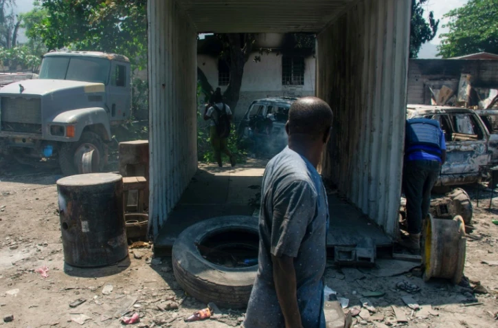 Un homme près de véhicules brûlés près de son garage à Port-au-Prince le 25 mars 2024