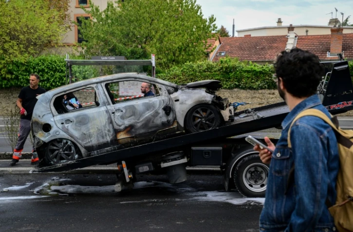 Une voiture brûlée lors d'une manifestation de lycéens devant le lycée André Cuzin à Caluire-et-Cuire, près de Lyon, le 30 septembre 2026