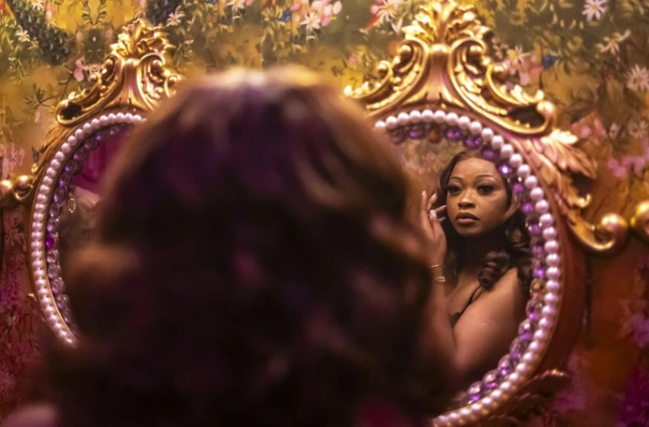 Une cliente se regarde dans le miroir dans les toilettes du restaurant et salon Zaza à Lagos, le 23 août 2025 au Nigeria