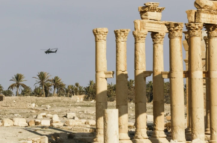 Un hélicoptère d'attaque survole le site détruit de Palmyre dans le centre de la Syrie, le 4 mars 2017