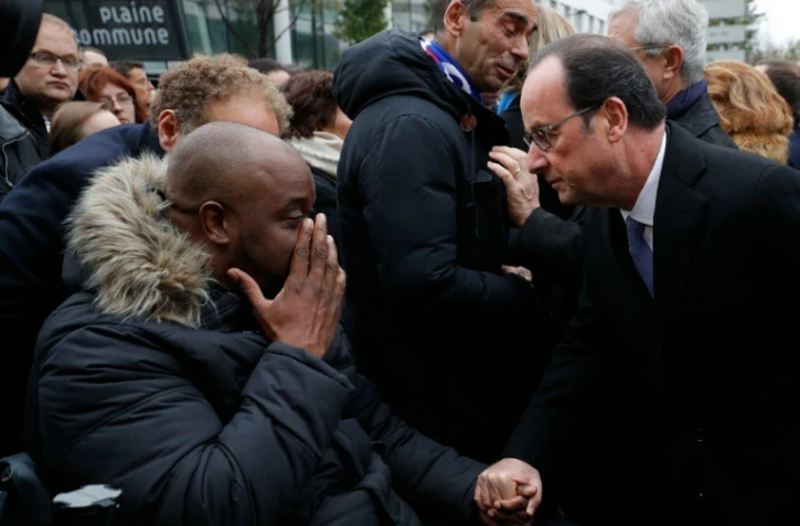 Le président Hollande s'entretient avec une victime des attentats de l'an dernier, lors d'une cérémonie du souvenir à l'extérieur du Stade de France, le 13 novembre 2016
