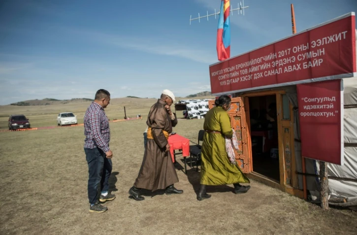 Des personnes entrent dans une yourte transformée en bureau de vote lors de la présidentielle, le 26 juin 2017 à Tuul Valley, en Mongolie