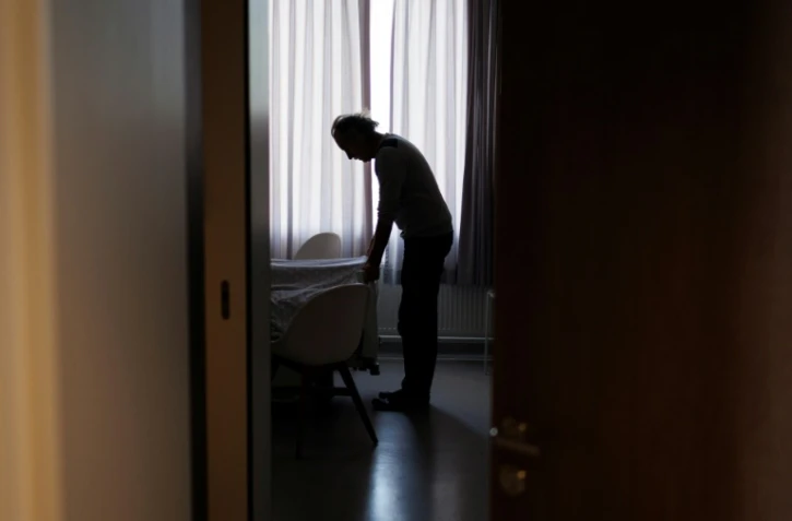 Denis Rousseaux, qui a accompagné Lydie Imhof, ajuste la couverture sur son lit d'hôpital à l'issue de son euthanasie, le 1er février 2024 en Belgique