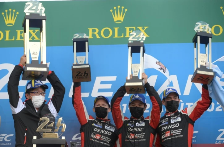 Le président de l'écurie Gazoo Racing, le Japonais Shiegeki Tomoyama (g), célèbre la victoire aux 24 Heures du Mans, de la Toyota N.7, pilotée par le Britannique Mike Conway, le Japonais Kamui Kobayashi et l'Argentin José Maria Lopez, le 22 août 2021
