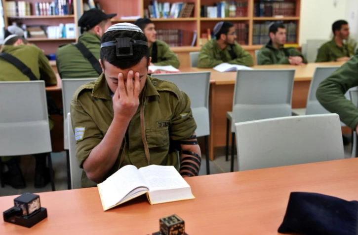 Un soldat juif pratiquant prie dans une synagogue installée dans une base militaire dans le désert du Néguev le 21 décembre 2015