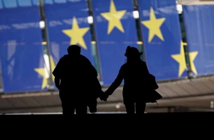 Un couple marche près des bâtiments du Parlement européen, le 9 juin 2024 à Bruxelles