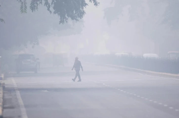 Un homme traverse la rue à New Delhi, plongée dans un brouillard de pollution, le 4 novembre 2019