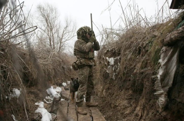 Un militaire ukrainien scrute les positions ennemies depuis une tranchée, près d'Avdiivka, dans le sud-est de l'Ukraine, le 9 janvier 2022