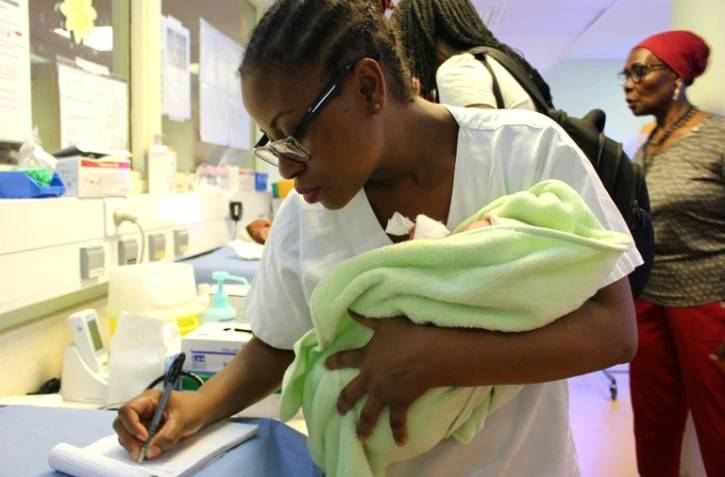 Une infirmière tient un nouveau-né contre elle le 14 mars 2018 à la maternité de Mamoudzou, chef lieu de l'île française de Mayotte