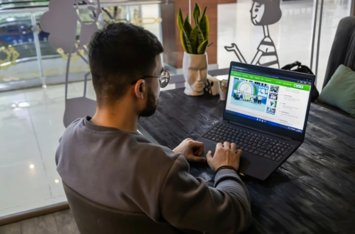 Un homme consulte les médias sur son ordinateur dans un café à Achkhabad, le 31 janvier 2024 au Turkménistan