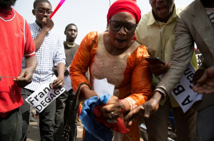 Une femme déchire un drapeau français pendant une manifestation le 10 janvier 2020 à Bamako
