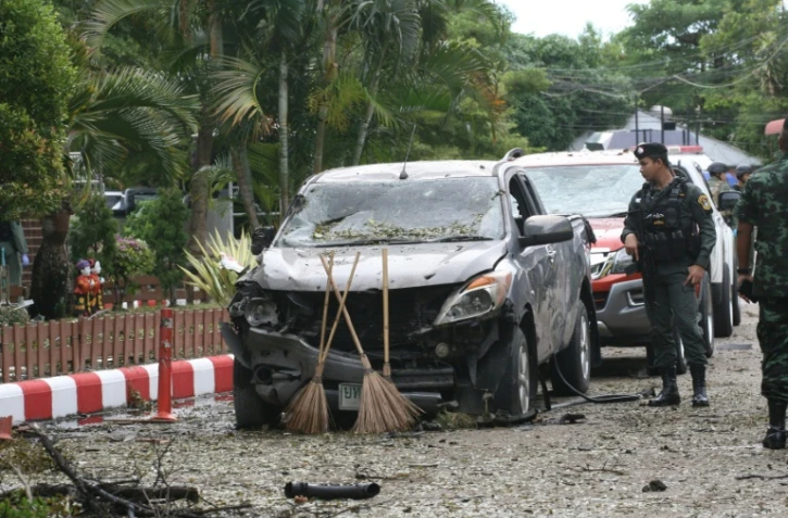 Un soldat thaïlandais inspecte une voiture carbonisée là où une bombe a explosé, à l'extérieur d'un hôtel dans la province de Pattani (sud), le 24 août 2016