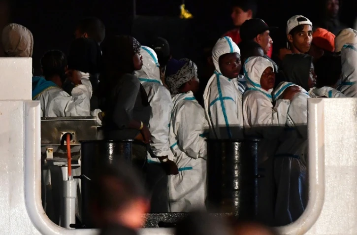 Des migrants attendent pour débarquer du navire italien Diciotti, le 20 juin 2018 à Pozzallo, en Sicile