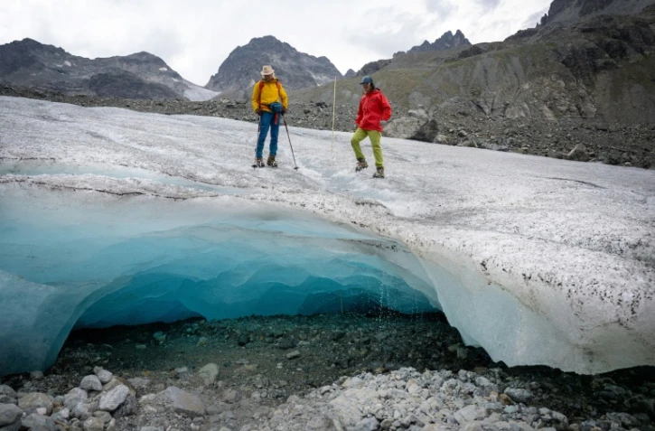 Les glaciologues Andrea Fischer (G) et Violeta Lauria, de l'Académie autrichienne des sciences, marchent sur le glacier Jamtal près de Galtür, en Autriche, le 20 juillet 2022