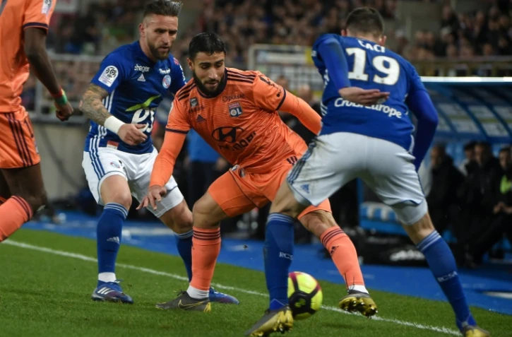 Le meneur de jeu de Lyon Nabil Fékir (c) entre deux joueurs strasbourgeois, le 9 mars 2019 à Strasbourg