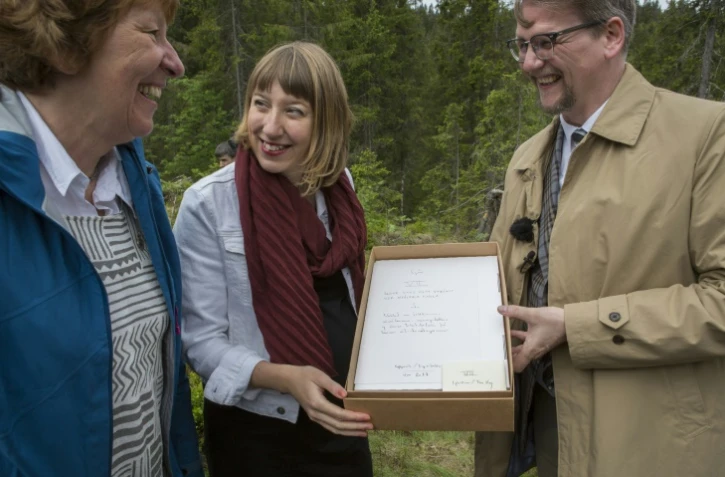 L'artiste écossaise Katie Paterson (c), la mair d'Oslo Marianne Borgen et l'auteur Sjon avec son manuscrit pour la bibliothèque du futur, dans une forêt près d'Oslo, le 2 juin 2017